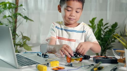 Boy Working on Toy Robot Car at Home