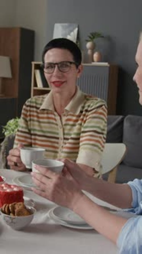 Frauen mittleren Alters versammelten sich am Tisch und unterhielten sich beim Teetrinken