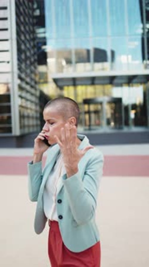 Businesswoman Talking on Phone Outside Modern Office Building