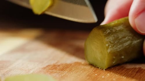 Pickled Cucumber Sliced into Rounds on Wood Board