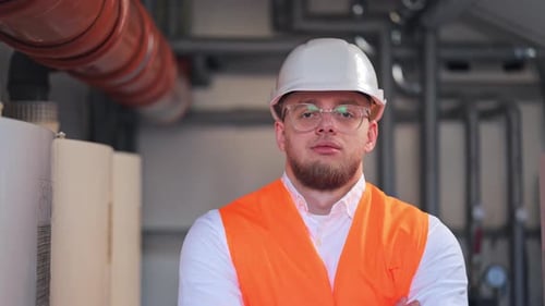Confident Industrial Engineer in Safety Hard Hat Looks Ahead