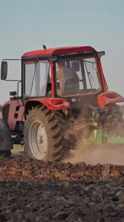 Tractor working in the field. Tractor cultivating and seeding a dry field
