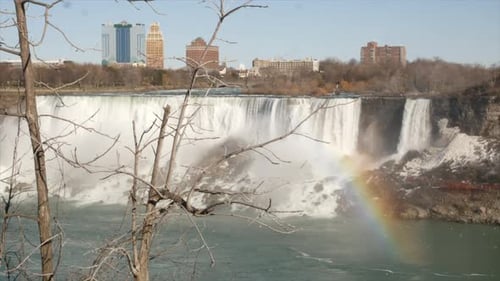 Wide shot over Niagara falls USA side with rainbow, Canada