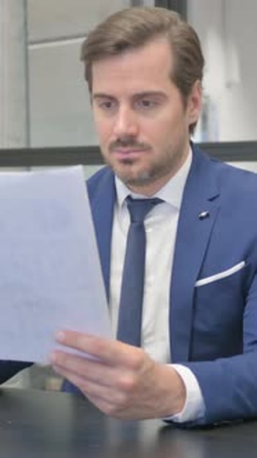 Mature Adult Businessman Reading Documents in Office, vertical video