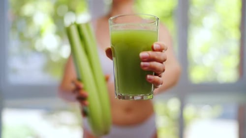 Woman Shows Celery and Juice for Healthy Lifestyle