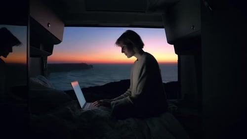 Woman Working on Laptop in Van at Sunset