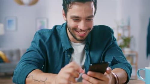 Smiling Man Using Smartphone in Bright, Modern Home