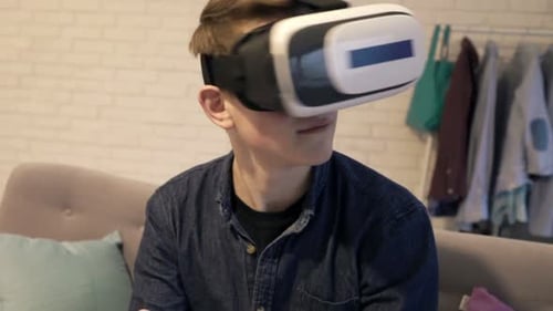 Teenage Boy Plays Virtual Reality Game at Home