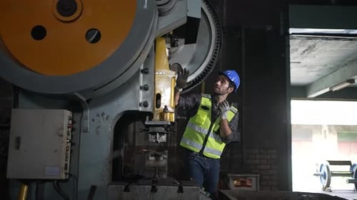 Engineer is working at machine part factory.