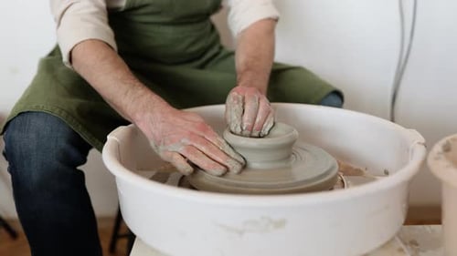Plat en céramique sculptant un potier pour homme adulte sur un tour de potier