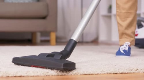 Vacuum Cleaner Hoovering Rug in Living Room
