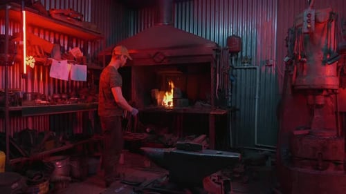 Blacksmith Works With Metal in a Glowing Forge