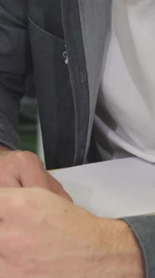 Closeup of Two Business Colleagues Analyzing Documents with Focus and Determination