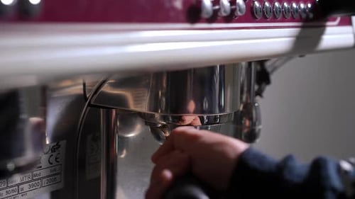 Closeup Attaching Portafilter to Espresso Machine Indoors in Cafe