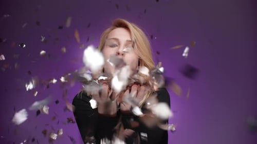 Woman Blowing Confetti for Birthday Celebration