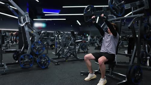 Fitness-Mann trainiert in einem modernen Fitnessstudio und macht eine Übung auf modernen