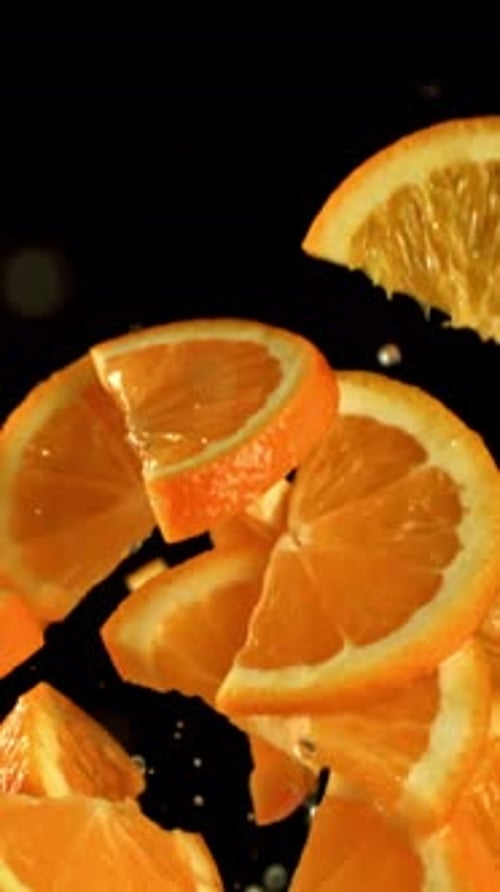 Orange Slices Flying on a Black Background Filmed on a Highspeed Camera at 1000 Fps
