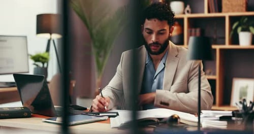 Man Writing at Desk in Professional Office