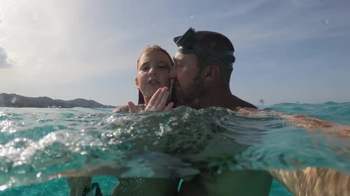 Father and Child Swimming Together in Turquoise Ocean