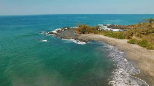 Aerial view of rocky tropical shoreline on a clear day in a coastal Costa Rica