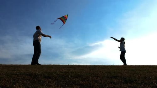 Father and Daughter Flying Kite on Open Field at Sunset, Steadicam