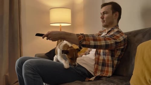 Man Relaxing on Couch with His Dog