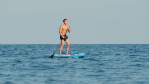 Man Navigate with Stand Up Paddle in the Sea