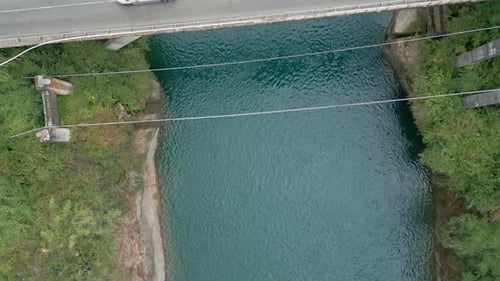 Top down view of turquoise river with bridge and forest. Malihue, Los Lagos, Chile