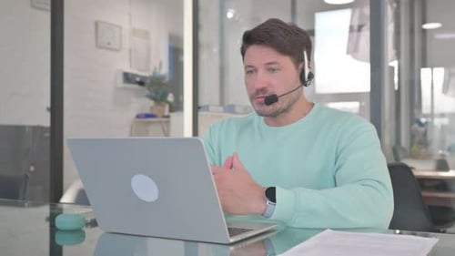 Man in Call Center with Headset Talking with customer Online