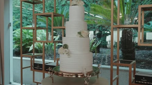 elegant white wedding cake with floral decoration on stand