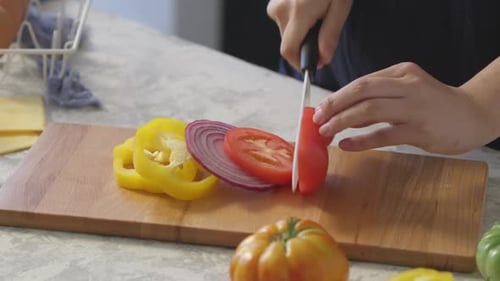 Slicing Fresh Red Tomato with Knife in Kitchen