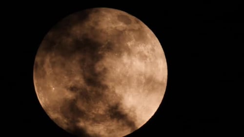 Full Moon Obscured by Clouds in Dark Sky