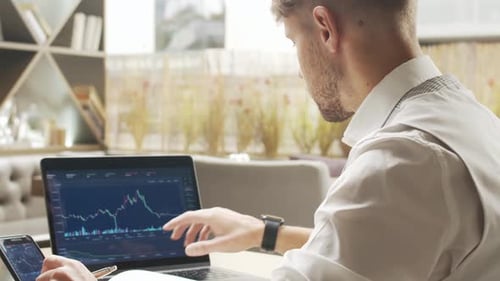 Businessman Sitting and Working in a Cafe Man Using Computer and Devices Business and