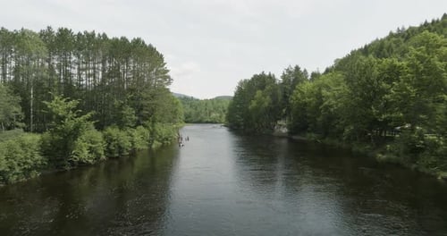 Drohne fliegt im Sommer über einen schönen Fluss und bewegt sich dann immer wieder auf. Leute schwimmen.