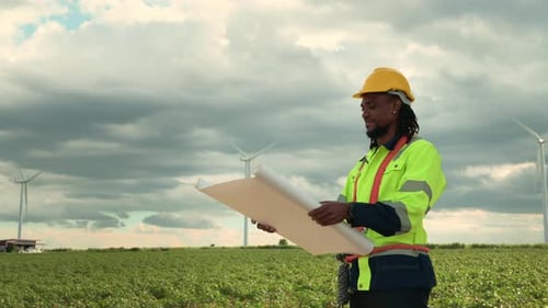 Smart engineer with protective helmet holding the blueprint working