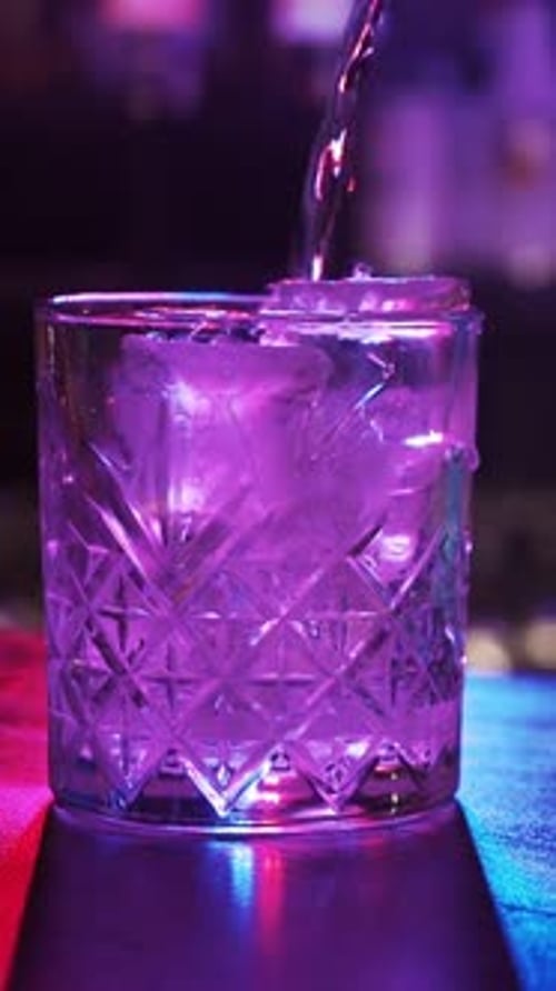Cocktail Being Poured over Ice in Patterned Glass