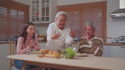 Three People Eating Salad Together at Kitchen Table
