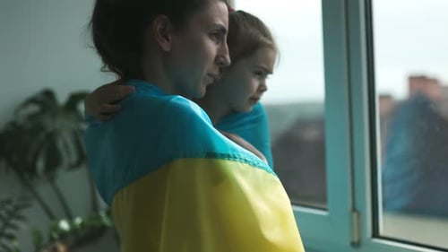 Woman and Child Wrapped in Flag Looking Out Window