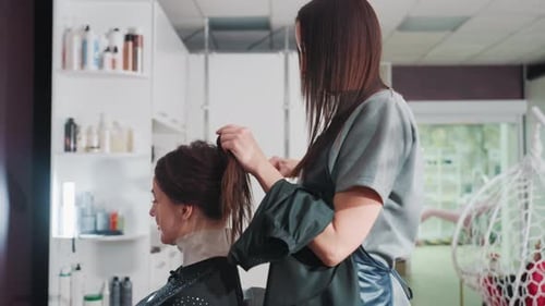 Caucasian Woman Stylist Braiding Client Hair Into Neat Updo for Wedding Precise Sections and Pins