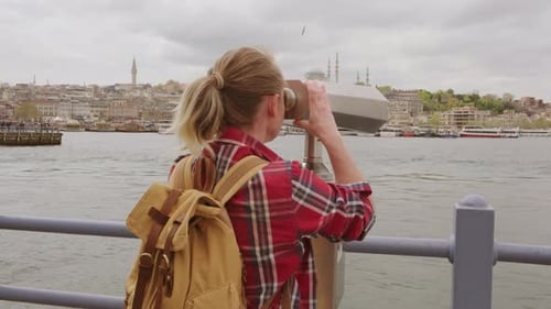 Woman Looking through Binoculars in an Urban Setting