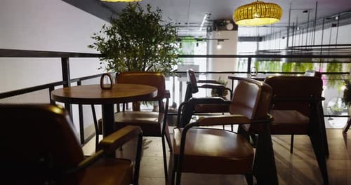 Contemporary Wooden Furniture And Woven Chandeliers In Cozy Restaurant Interior Of Vegetarian Cafe