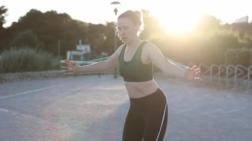 Woman Working Out With Resistance Band Outdoors