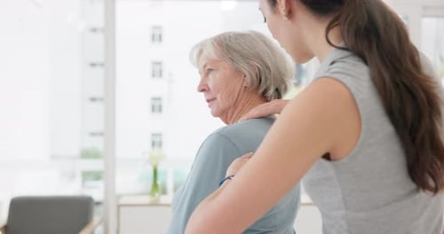Young Woman Massaging the Shoulders of Senior Woman