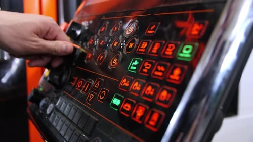 Employee Turns Handles on Control Panel Tuning Machine Tool