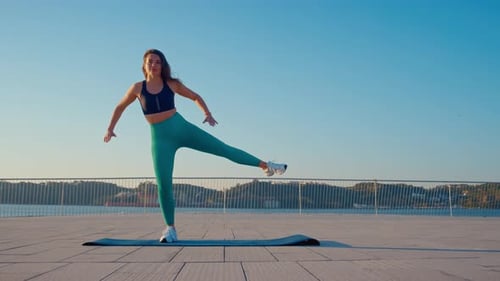 Athletic Woman Performing Leg Lift Exercise Outdoors