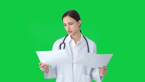 Indian female doctor checking medical reports Green screen