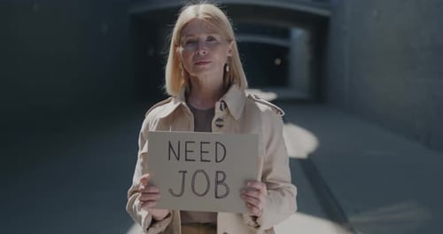Portrait of Unemployed Mature Lady Looking for Work Holding Need Job Sign Standing in City