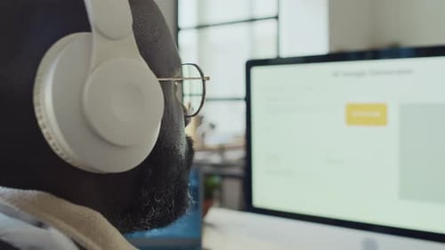 Black Male Programmer in Headphones Testing AI Image Generation Software