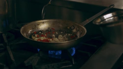 Chef adding ingredients to pan on stovetop