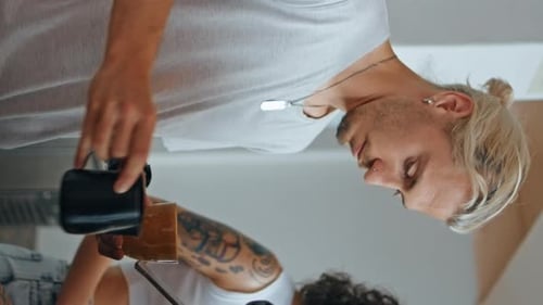 Young Adults Pour Coffee in Home Kitchen